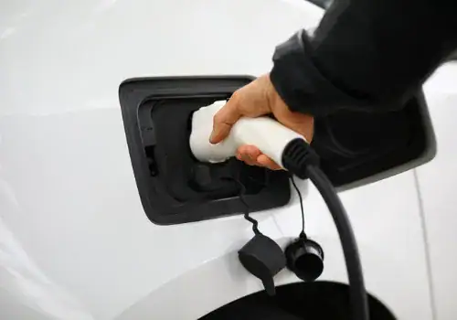 driver inserts electric charger into vehicle closeup picture id1315330060.jpg