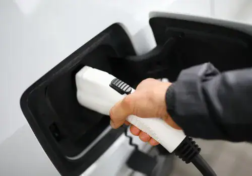 male hand hold probe connector car charging station closeup picture id1277789647.jpg