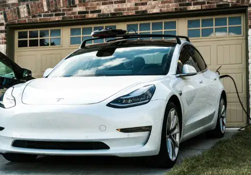 tesla model 3 parked at home with charging cable plugged in picture id1296607227.jpg